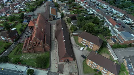 Traditional-church-wedding-ceremony-aerial-orbit-right-tilt-up-view-above-St-Georges-Enfield-townscape