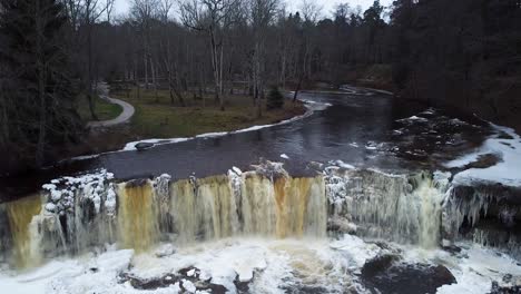 Aerial-drone-view-of-a-frozen-waterfall-in-winter