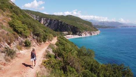 Girl-walking-to-Gjipe-Beach-and-Canyon-in-Dhermi,-Albania---Aerial-Drone-View