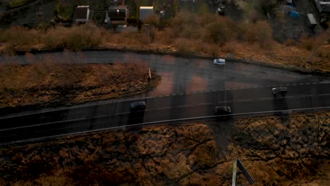 Cars-Driving-Through-Asphalt-Road-At-Dusk-From-Above
