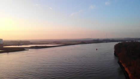 Aerial-Over-Oude-Maas-River-With-Orange-Sunrise-Skies-Near-Puttershoek
