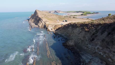 Porto-Novo-Beach,-Zvernec,-Vlore,-Albania---Aerial-Drone-View-of-the-Rocky-Coastline-with-Motorhomes,-Campers-and-Vans