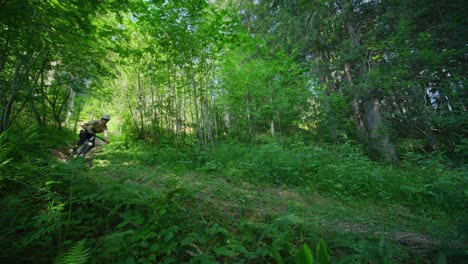 A-mountain-biker-rides-through-a-dense-forest-in-slow-motion