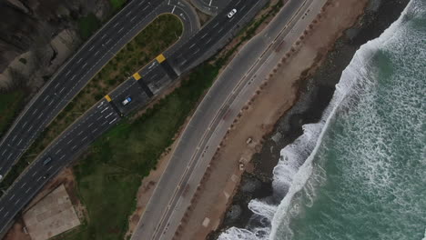 Top-down-view-of-a-road-junction-in-a-Peruvian-highway-at-the-side-of-the-beach