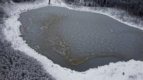 Aerial-drone-view-of-a-frozen-bog-lake-in-winter