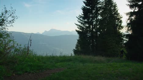 A-mountain-biker-rides-fast-along-an-alpine-ridge-at-dawn