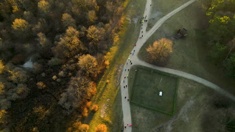 Gruppe-Von-Läufern,-Die-Bei-Sonnenaufgang-Einen-Marathon-In-Einem-Park-Laufen-Przymorze-Polen---Luftbild-Von-Oben-Nach-Unten