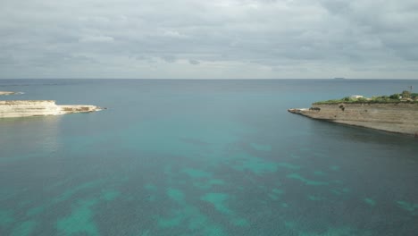 AERIAL:-Ta-Kalanka-Sea-Cave-Bay-with-Cloudy-Sky-and-Beautiful-Turquoise-Color-Water