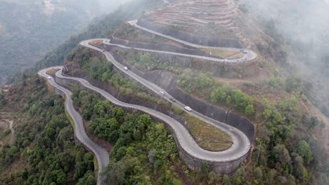 An-aerial-view-of-traffic-on-the-BP-Highway,-Bardibas-Highway,-showing-the-switchbacks-and-turns-as-it-winds-through-the-hills-of-Nepal