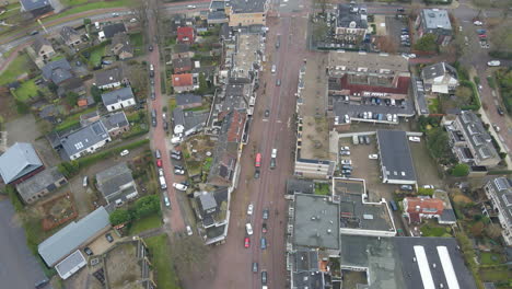 Aerial-of-cars-driving-over-busy-road-in-small-town-shopping-district
