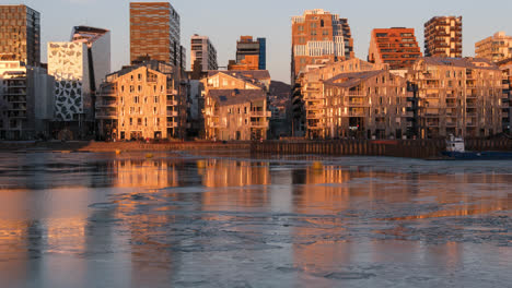 Golden-Hour-Timelapse-of-Oslo-Skyline,-Norway-with-Ice-and-Reflection