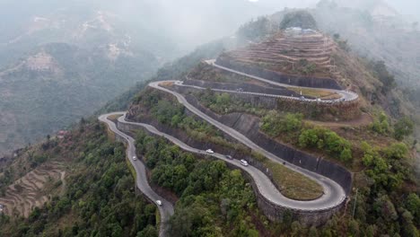 An-aerial-view-of-traffic-on-the-BP-Highway,-Bardibas-Highway,-showing-the-switchbacks-and-turns-as-it-winds-through-the-hills-of-Nepal