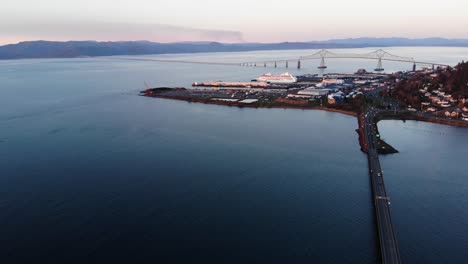 Aerial-seascape-view-of-Astoria-sunset-cityscape-with-New-Youngs-Bay-bridge-connecting-Washington-with-Oregon