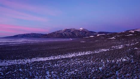 Pink-and-purple-sunset-or-sunrise-over-a-mountain-peak-in-the-winter
