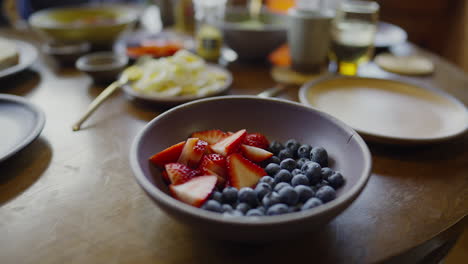 Close-up-view-of-a-bowl-of-fruit-with-breakfast-in-the-background