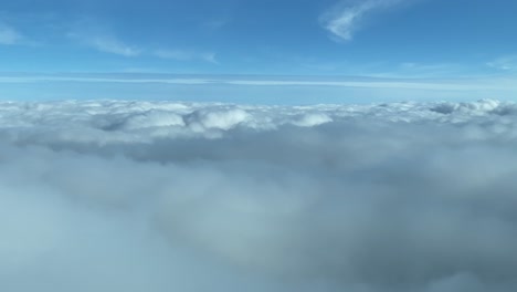 Aerial-view-from-a-cockpit-surfing-clouds-with-a-blue-skay-and-day-light