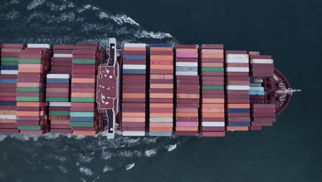 Aerial-top-view-of-a-loaded-container-cargo-vessel-traveling-over-ocean