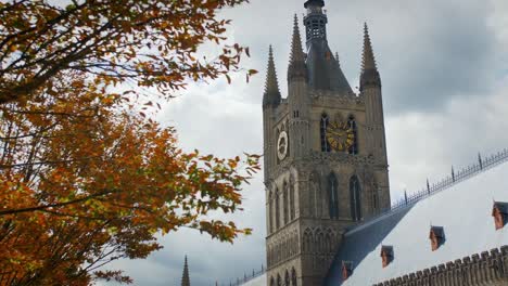 European-Church-in-Ypres-Belgium-on-a-cloudy-day,-Autumn-Fall-with-tree-leaves-turning-orange