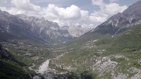 Video-De-Drone-Frontal-Avanzando-Dentro-Del-Valle-De-Theth-En-Albania,-Sobre-El-Río-Lumi-I-Thethit-Sin-Apenas-Agua,-Con-El-Monte-Korab-Al-Fondo