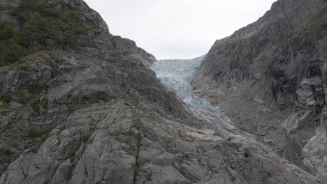 Gefrorene-Gletscherkaskaden-Felsige-Berghänge-Hinunter,-Luftaufnahme
