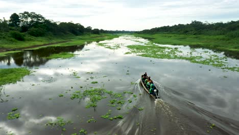 People-on-Boat-Navigating-the-Amazon-River-in-Peru---Aerial-Following-Shot