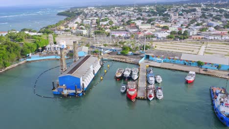 Descending-aerial-shot-of-industrial-Harbor-of-Puerto-Plata-with-Caribbean-Sea-in-background
