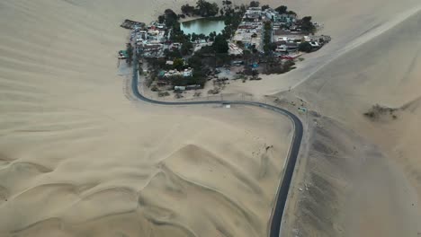 Aerial-Reveal-of-Famous-Huacachina-Village-in-the-Peru-Sand-Dune-Desert