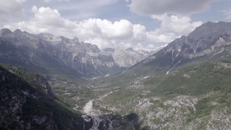 Frontales-Drohnenvideo,-Das-Sich-Im-Theth-Tal-In-Albanien-Fortbewegt,-über-Dem-Fluss-Lumi-I-Thethit-Mit-Kaum-Wasser,-Mit-Dem-Berg-Korab-Im-Hintergrund