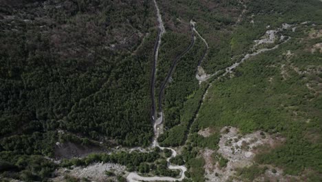 Video-De-Dron-De-Panorámica-Descriptiva-Frontal-En-La-Carretera-Sh21-En-Albania,-En-El-Camino-Hacia-El-Valle-Theth,-Que-Termina-Con-El-Monte-Korab-Como-Plano-Principal,-Se-Puede-Ver-La-Carretera-Con-Curvas-Y-Tráfico