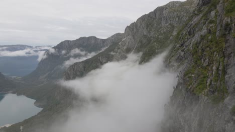 Hohe-Moosige-Felsige-Bergseite-Mit-Flauschigen-Wolken