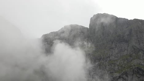 Fliegen-In-Der-Nähe-Von-Flauschiger-Wolkenlandschaft-Mit-Majestätischen-Felsigen-Bergen-Am-Horizont