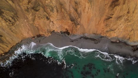 Aerial-Bird's-Eye-View-of-Ocean-Waves-crashing-into-Cliffs-on-Peru-Coastline-in-Paracas