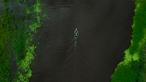 Breathtaking-Aerial-of-People-Boating-on-Lush-Amazon-River-in-Peru