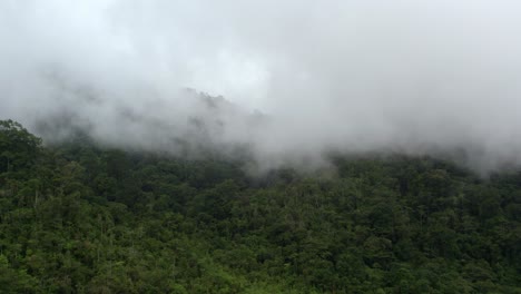 Aerial-view-of-Chirripo-green-dense-woodland-hills-covered-with-white-foggy-clouds-in-Canaan-de-Rivas,-Costa-Rica