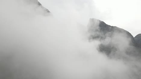 Drohne-Fliegt-Durch-Dichte-Wolkenlandschaft-In-Richtung-Felsige-Berge