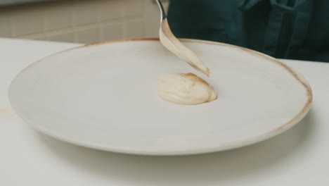 Chef-smears-home-made-mayonnaise-over-big-plate