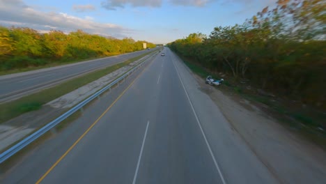Drohnengeschwindigkeitsflug-über-Die-Autobahn-Mit-Dem-Verkehr,-Der-An-Sonnigen-Tagen-In-Der-Ländlichen-Gegend-Der-Dominikanischen-Republik-Dem-Auto-Auf-Der-Straße-Folgt