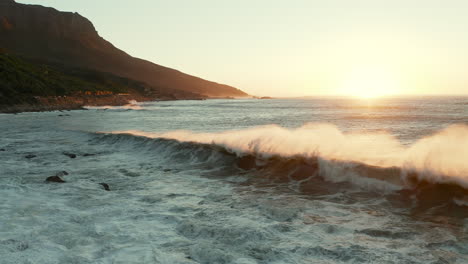 Sea-Waves-Crashing-In-The-Rocky-Shoreline-Of-Beach-At-Sunset-In-Cape-Tow,-South-Africa