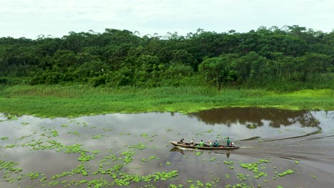 People-Traveling-on-Amazon-River-with-Lush-Jungle-Rainforest-in-Background---Aerial-Tracking-Shot