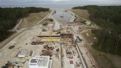 Aerial-orbit-shot-of-the-huge-construction-site-of-the-Vistula-Spit-canal,-shipping-channel-for-container-ships