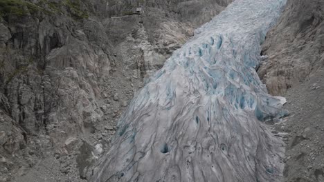 Massive-glacier-on-rocky-hillside-in-aerial-drone-shot