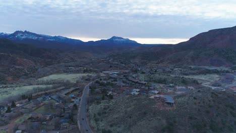 Drone-shot-flying-down-the-middle-of-Springdale,-Utah-on-a-cloudy-evening