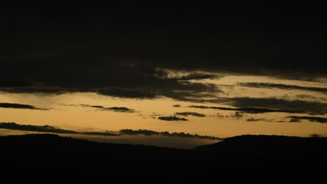 Schöner-Sonnenuntergang-Und-Silhouette-Der-Hügel-Mit-Vorbeiziehenden-Wolken