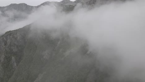 Majestuoso-Paisaje-Montañoso-Con-Nubes-Esponjosas-Rodando,-Vista-Aérea-De-Drones