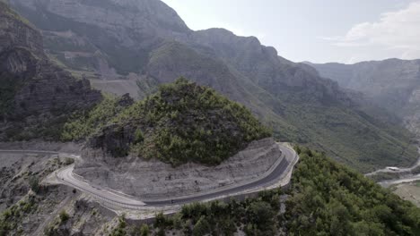 Drone-video-of-empty-description-plane-over-the-"Rrapsh-Serpentine"-mountain-pass-on-the-Sh20-road-in-Grabom,-Albania,-you-can-see-a-motorcycle-passing-by