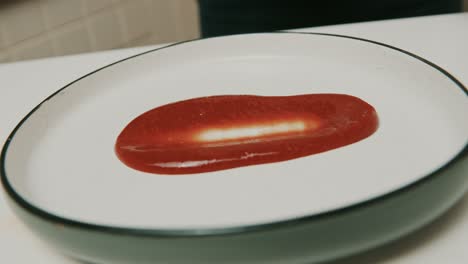 Chef-smears-home-made-ketchup-over-a-big-plate