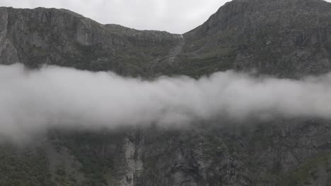 Felsige-Bergkette-über-Flauschiger-Wolkenlandschaft,-Luftschwenk-Rechts