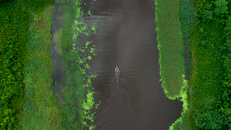 Boat-on-Beautiful-Amazon-River-Traveling-through-Lush-Rainforest-Jungle---Aerial