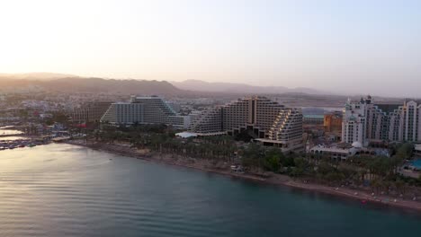 Luxury-hotels-and-resorts-by-red-sea-beach-at-Eital-city-in-south-Israel,-golden-hour