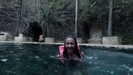 Caucasian-Female-Jumping-into-a-Cold-Natural-Pool-With-Forest-in-the-Background